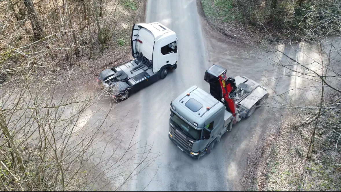 Zwei Woodsped-LKW beim Wechsel der Auflieger im Wald